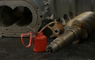 Lubrificação de componentes internos de compressor industrial com óleo específico para manutenção de compressores de ar.