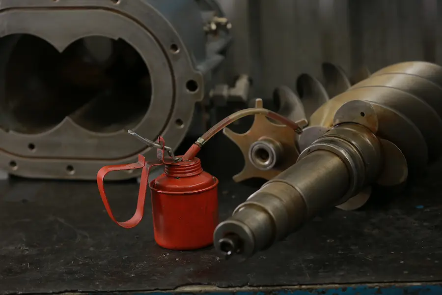 Lubrificação de componentes internos de compressor industrial com óleo específico para manutenção de compressores de ar.