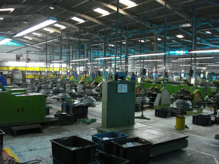 Linha de produção industrial com máquinas e equipamentos pneumáticos em operação.